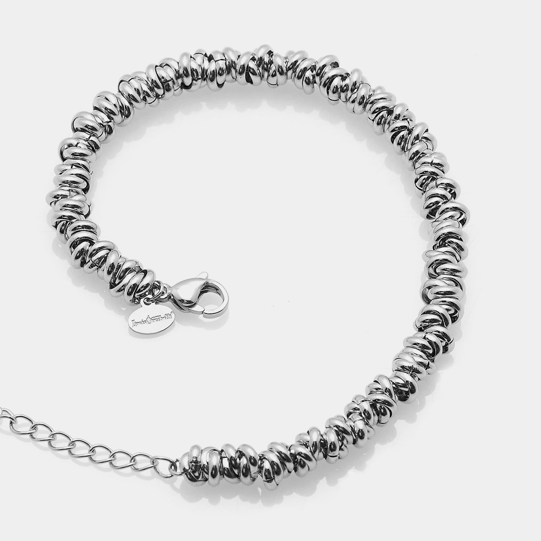 Shiny steel bracelet made of intertwined rings in the shape of knots