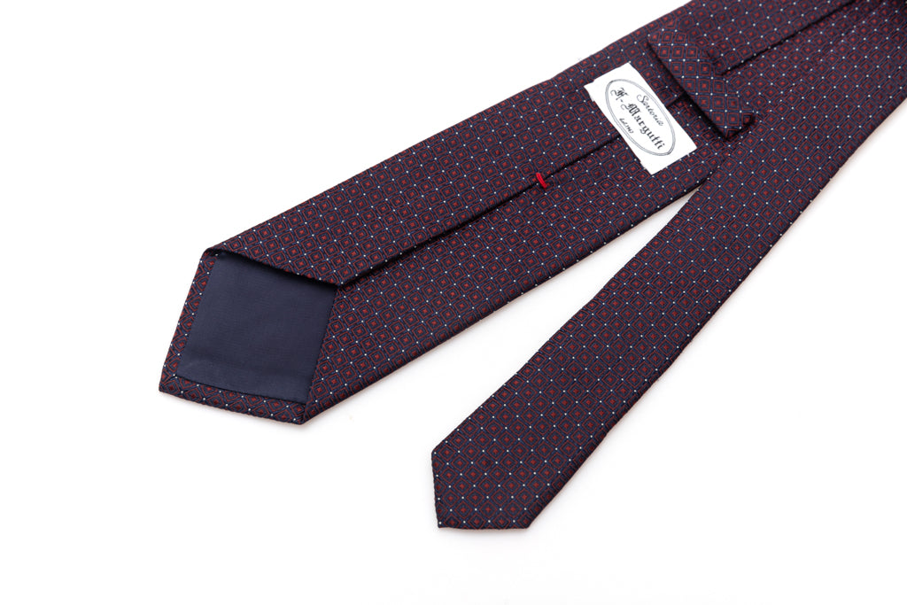 Blue tie with red geometries in pure silk
