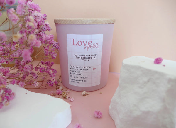 Naravna dišeča sveča Love Spell v roza ali beli stekleni posodici – romantična lesno-cvetoča aroma s kokosovim mlekom, mošusom in belimi cvetlicami.