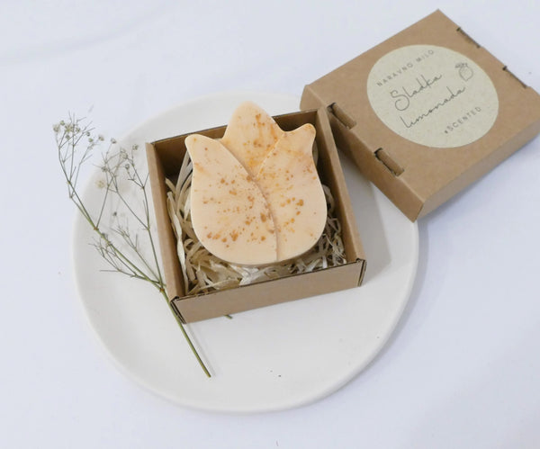 Ročno izdelano naravno milo z eteričnim oljem limonske trave v zlati barvi, elegantno zapakirano v škatlici.