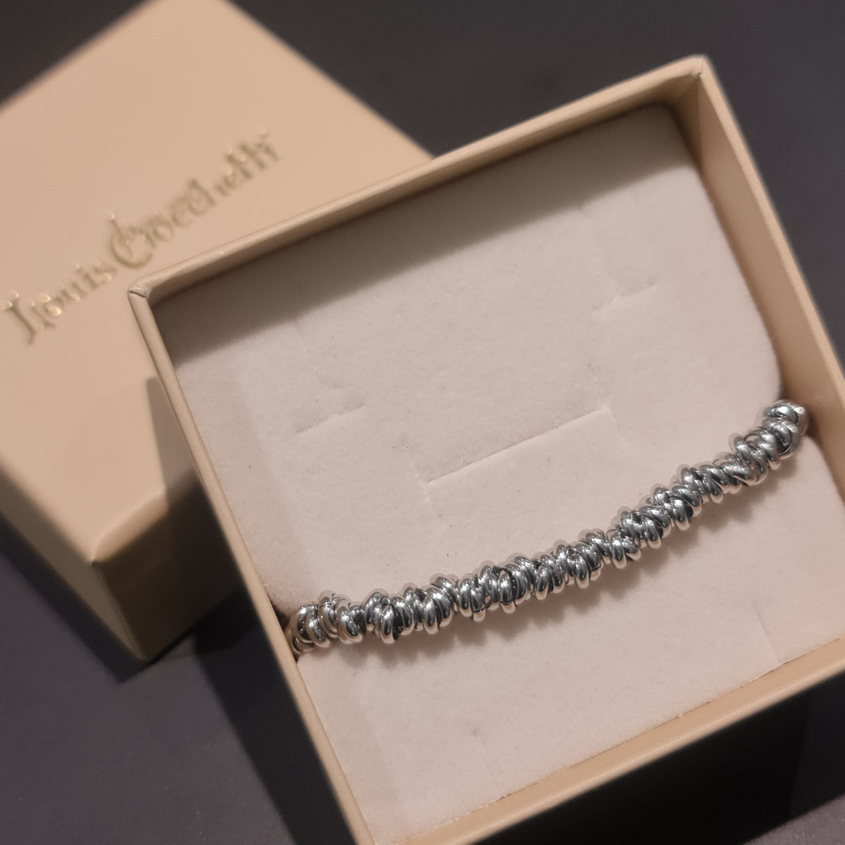 Shiny steel bracelet made of intertwined rings in the shape of knots