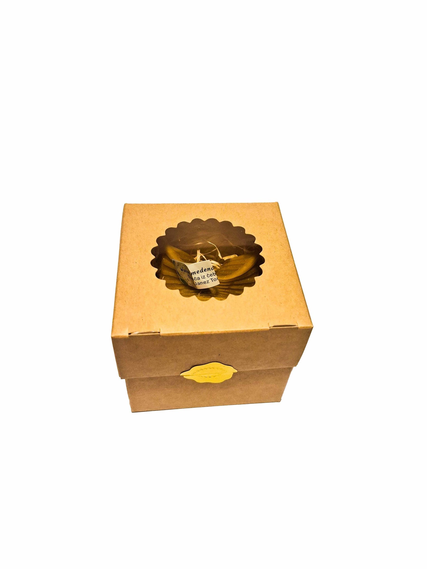 Elegant candle with fringes in a box with wood wool