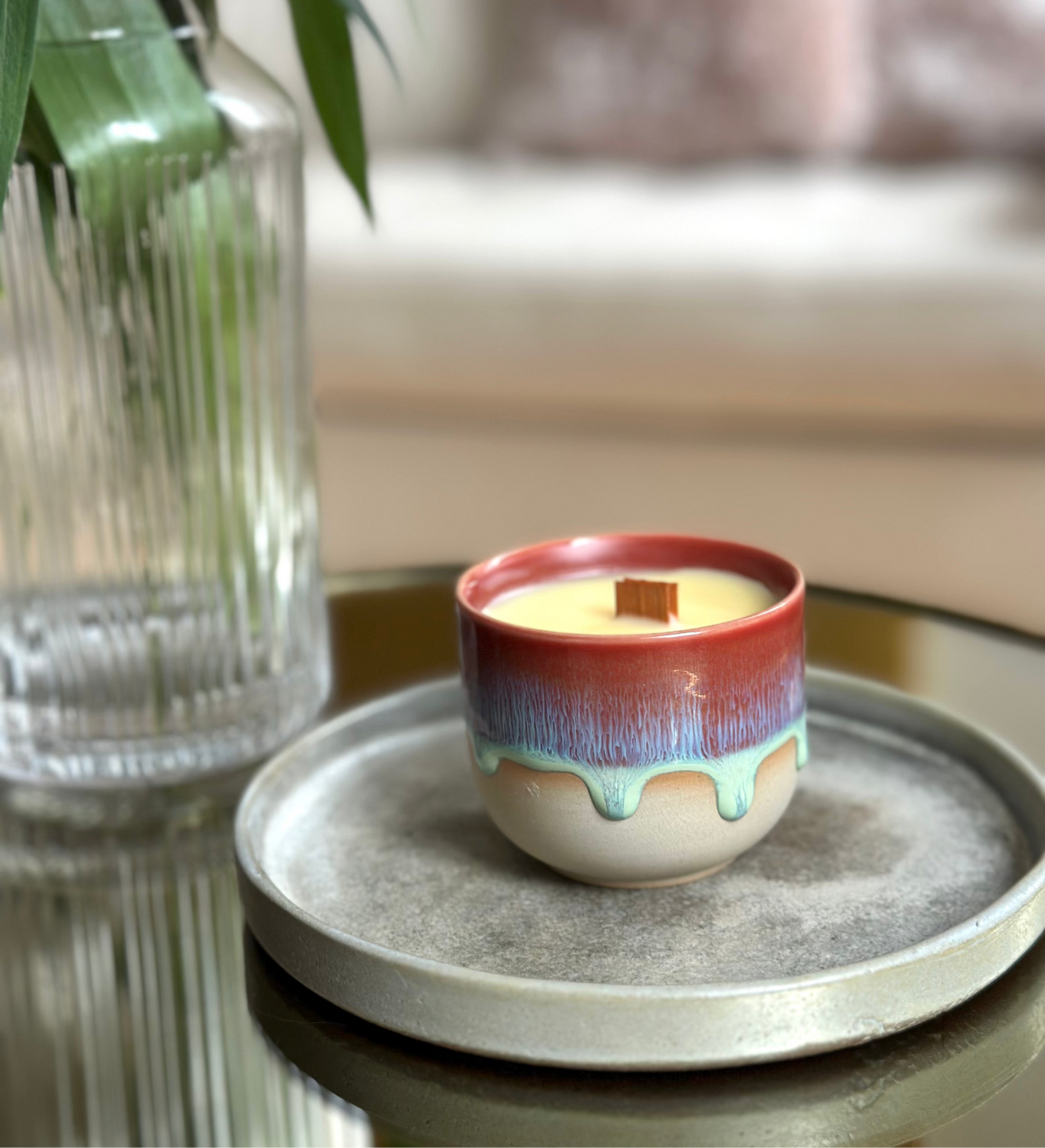 Colorful ceramic candle on a gray tray with a blurred background