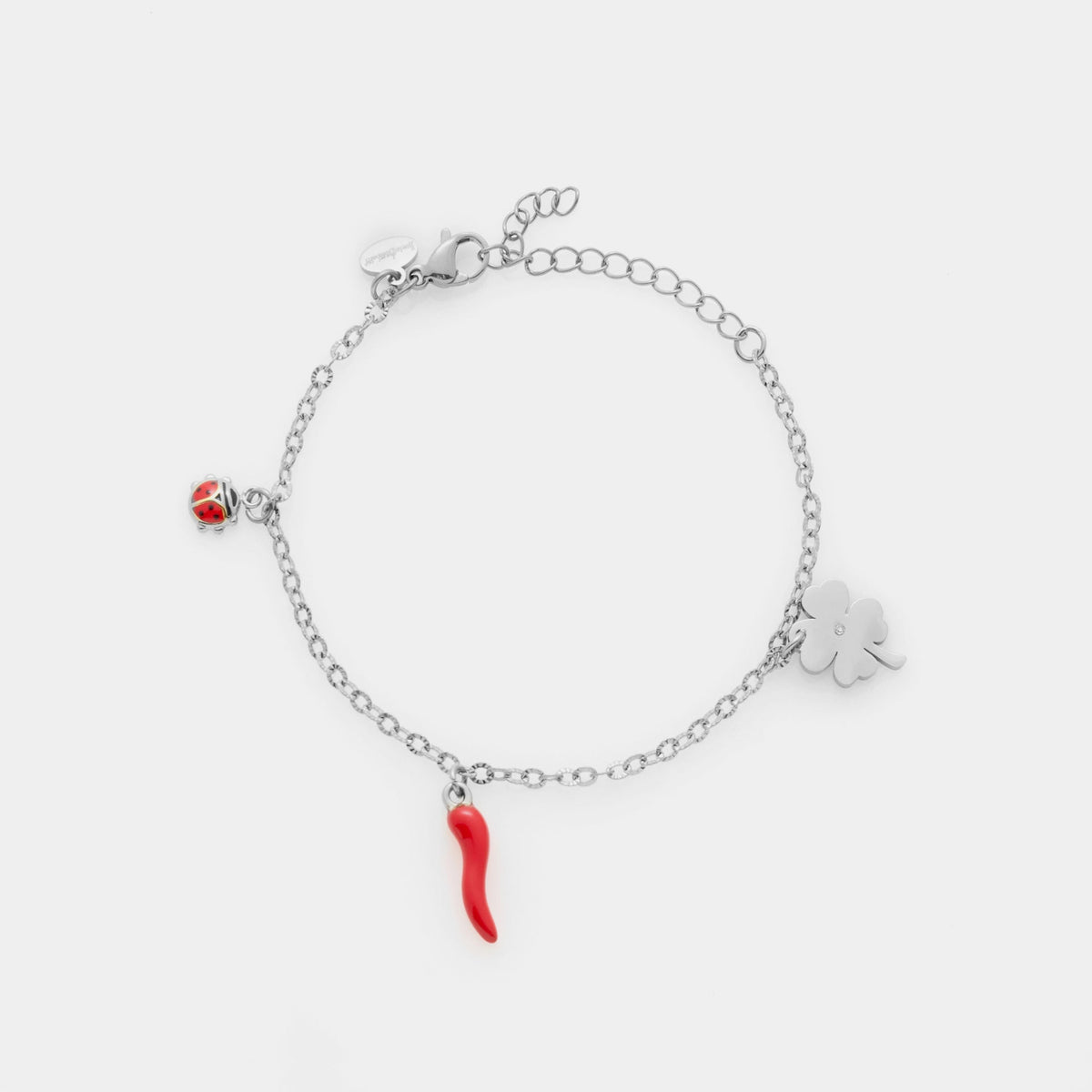 Fine steel bracelet with three charms: clover, red enamel horn, and red enamel ladybug
