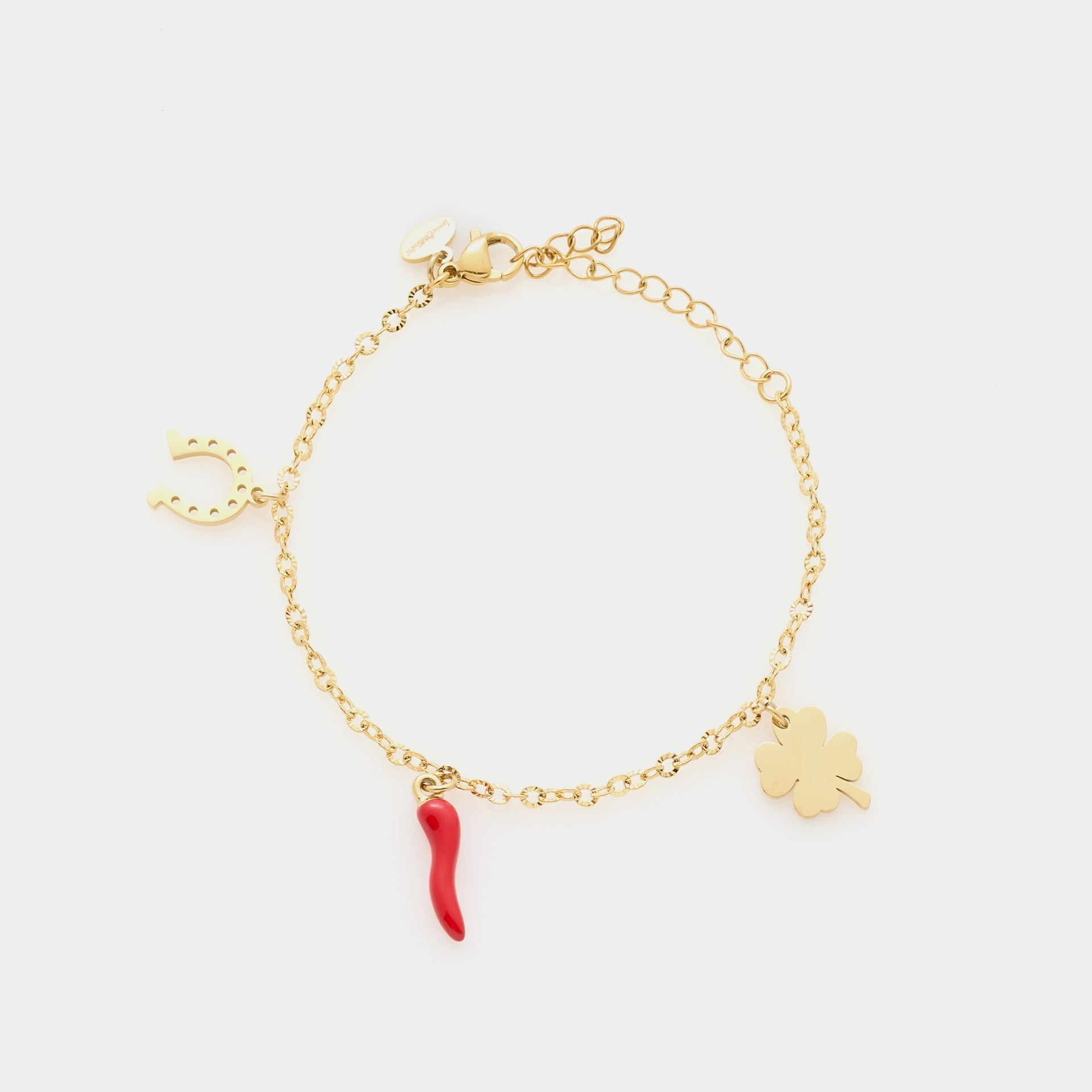 Gold-plated steel bracelet with fine rolò chain and three gold-plated charms: shamrock, red enamel horn, and horseshoe