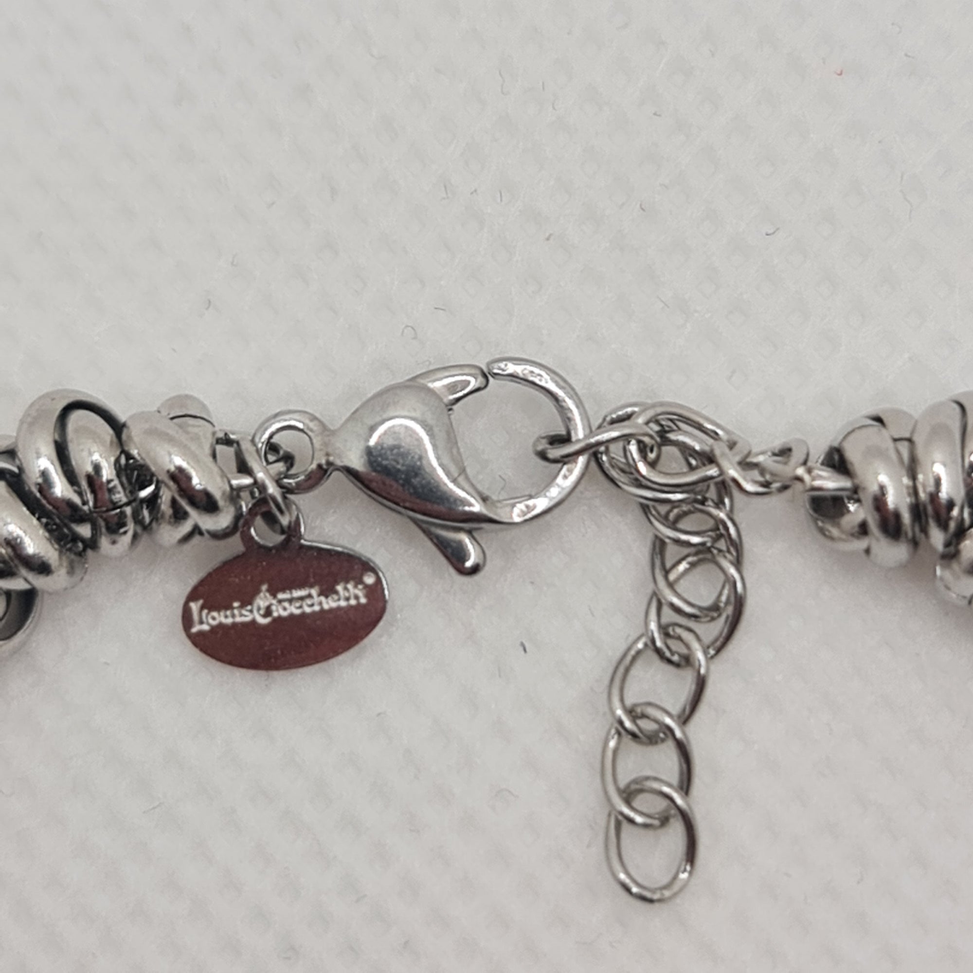 Shiny steel bracelet made of intertwined rings in the shape of knots
