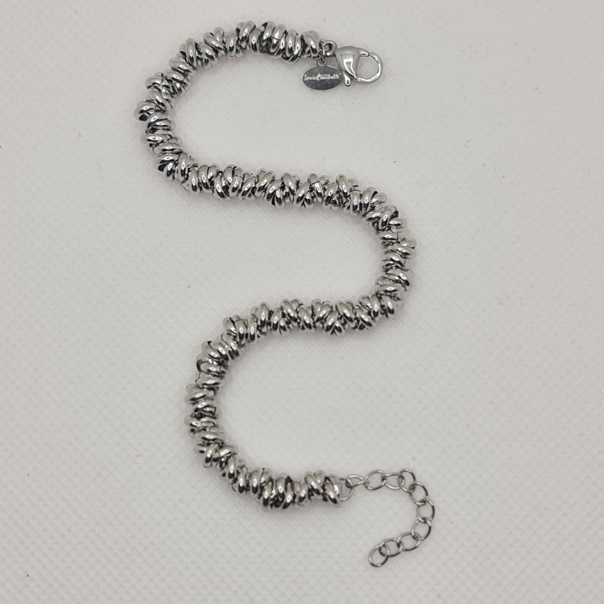 Shiny steel bracelet made of intertwined rings in the shape of knots