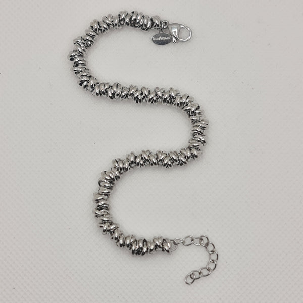 Shiny steel bracelet made of intertwined rings in the shape of knots