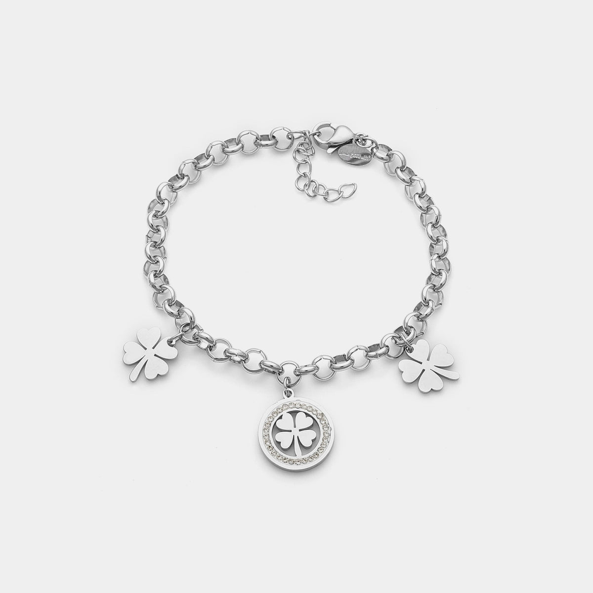 Pulsera de acero con cadena rolo que presenta 2 tréboles de cuatro hojas colgantes y 1 trébol central con piedras blancas