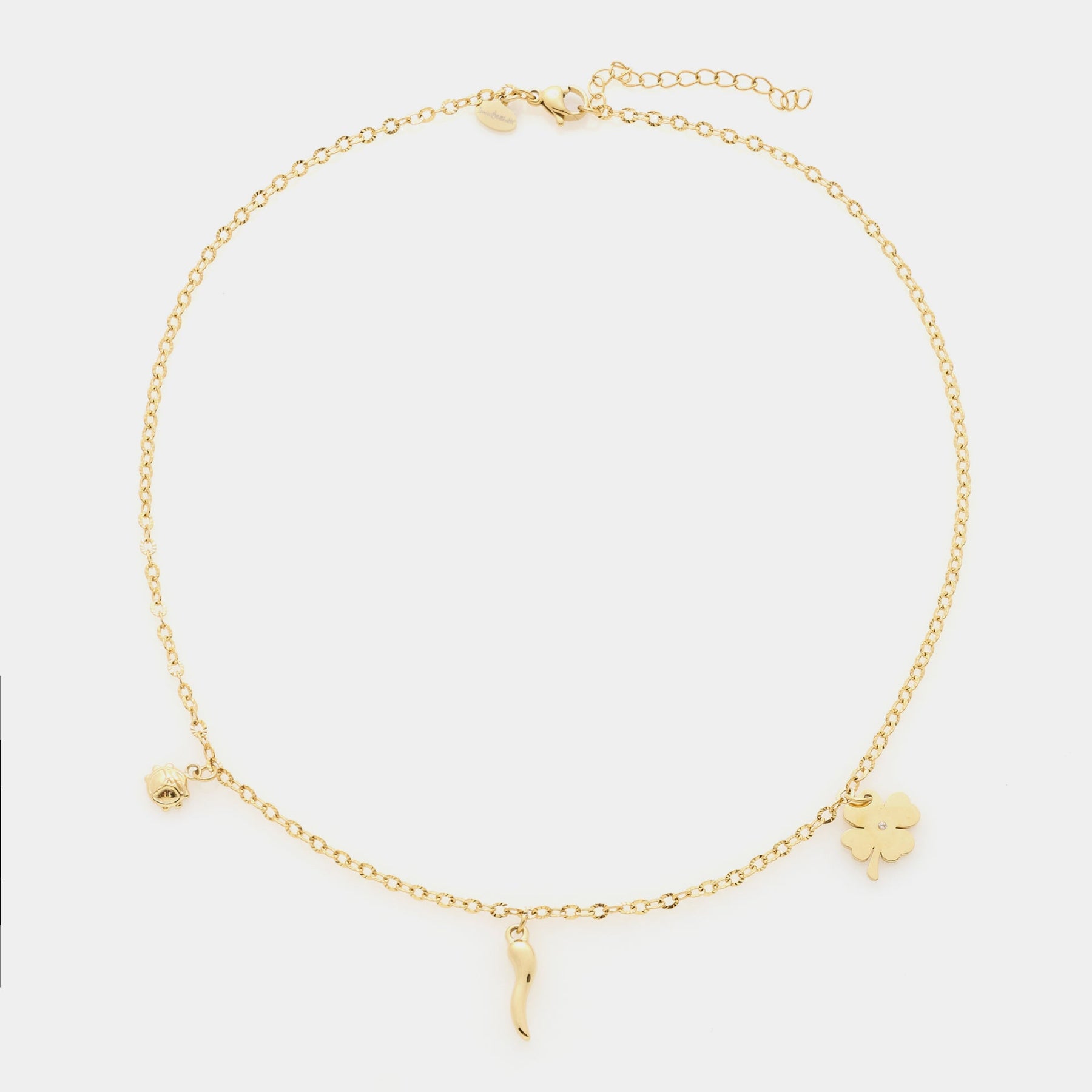 Gold-plated steel bracelet with fine rolò chain and three gold-plated steel charms: clover, horn, and ladybug
