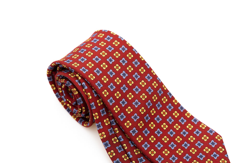 Cravatta a base rossa con motivo geometrico in pura lana