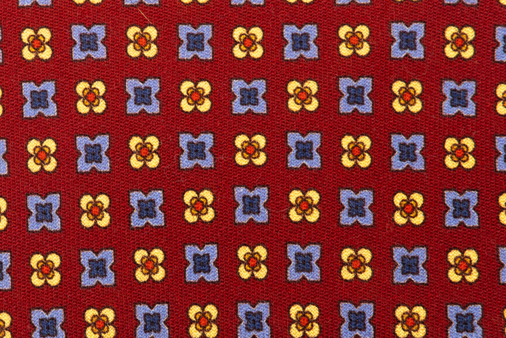 Cravatta a base rossa con motivo geometrico in pura lana
