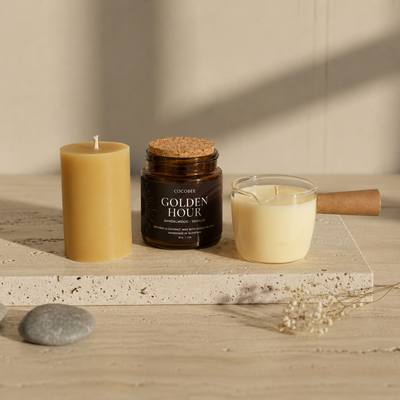 Three candles on a wooden surface with a neutral background
