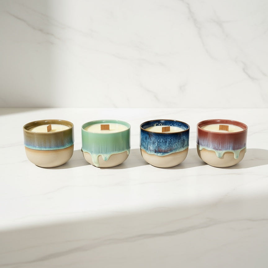 Four ceramic wood wick candles with different color glazes on a white surface. Beeswax & Coconut Wax - CocoBee.