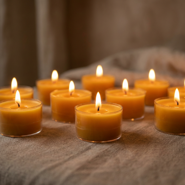 Small candles with a warm glow on a textured fabric surface