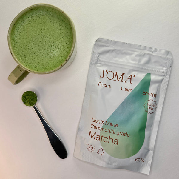 SOMA matcha packaging with a cup of matcha and spoonful of matcha powder on a white background