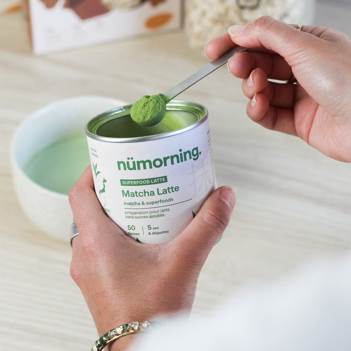 Gros plans sur le mélange en poudre pour matcha latte bio de nümorning avec une cuillère doseuse