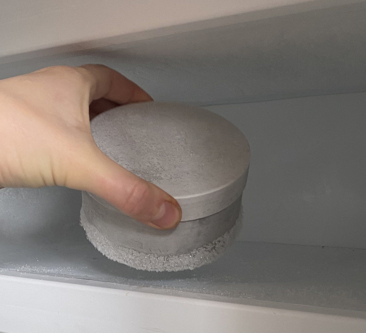 Coolenator wine cooler freezer bullet frozen in the freezer being put in by a hand