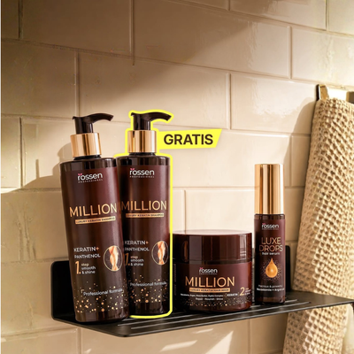 Hair care display on a shower shelf: two large Million keratin shampoo bottles with gold pumps, a Million mask jar, Luxe Drops serum bottle, and a towel nearby; yellow GRATIS tag in the background.