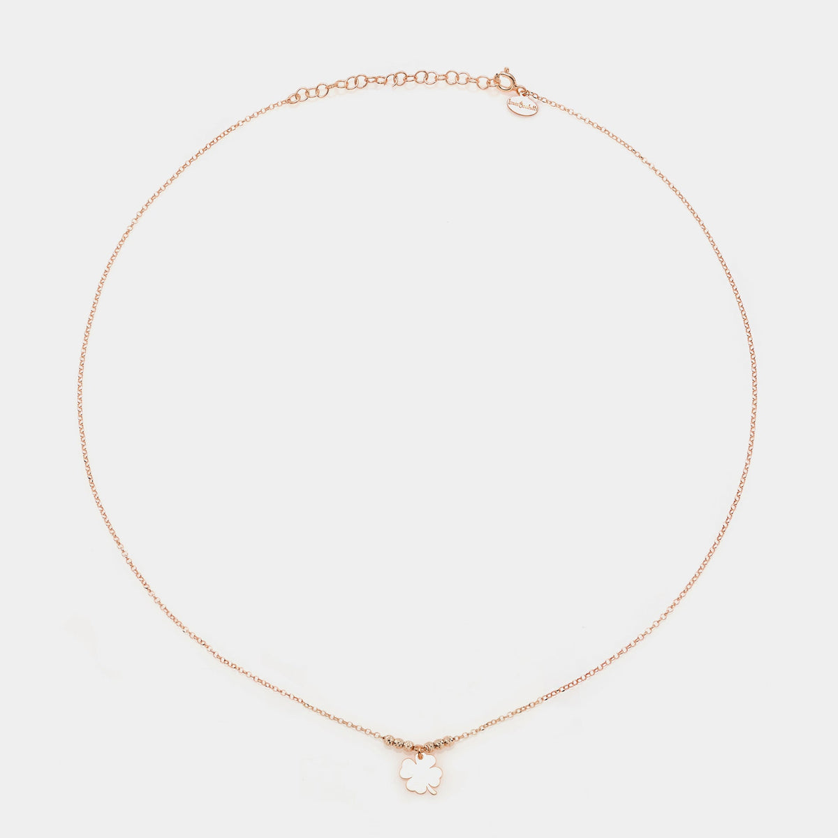 Rose gold silver necklace with a central hanging four-leaf clover and 3 faceted spheres on the sides