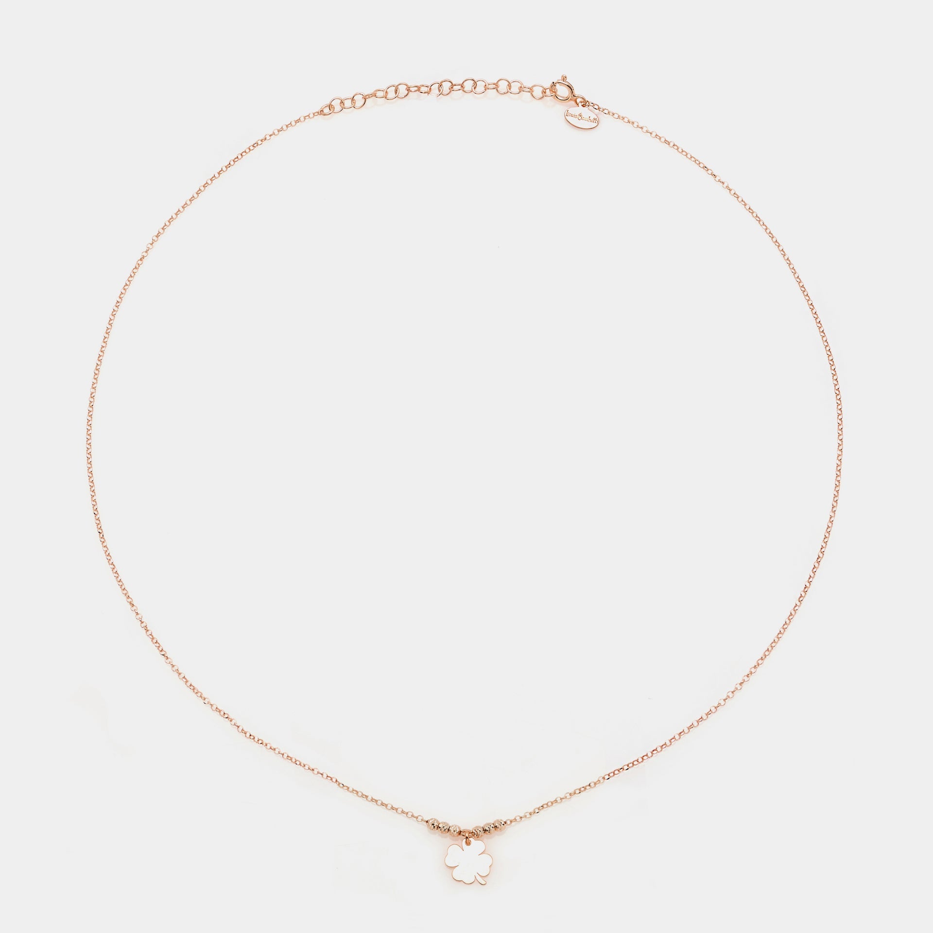Rose gold silver necklace with a central hanging four-leaf clover and 3 faceted spheres on the sides