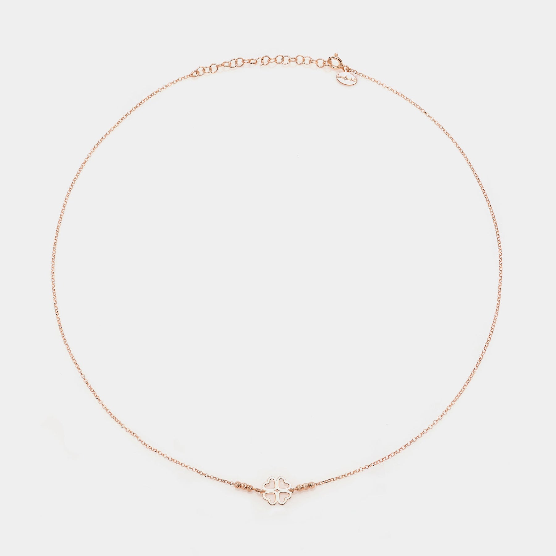 Rose gold silver necklace with clover centerpiece with heart-shaped pierced petals and 3 faceted spheres on the sides