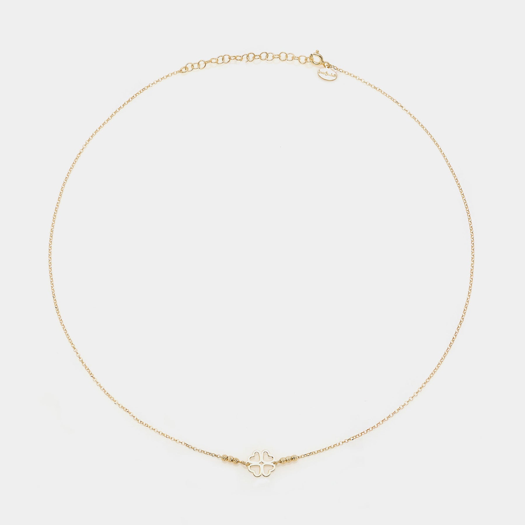 Gold-plated silver necklace with a central four-leaf clover with heart-shaped cutout petals and 3 faceted spheres on the sides