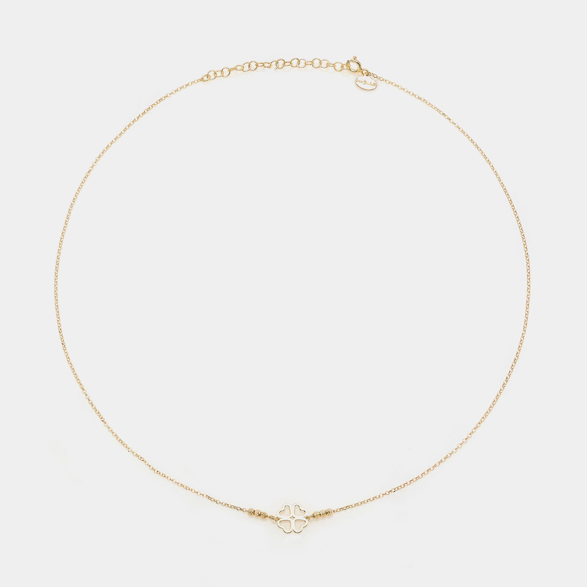 Gold-plated silver necklace with a central four-leaf clover with heart-shaped cutout petals and 3 faceted spheres on the sides