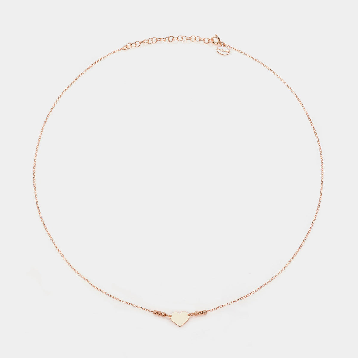 Rose gold silver necklace with simple heart centerpiece and 3 faceted spheres on the sides