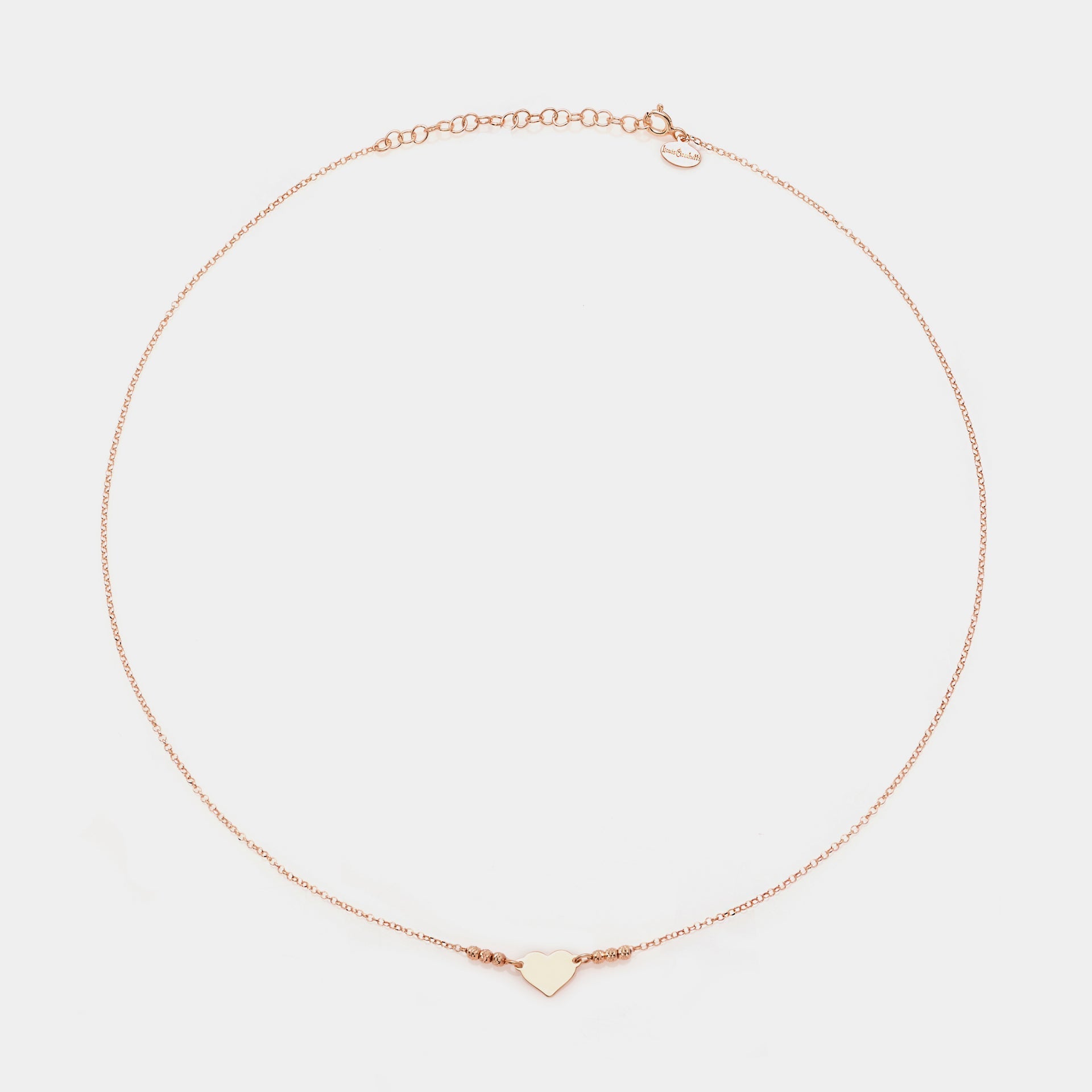 Rose gold silver necklace with simple heart centerpiece and 3 faceted spheres on the sides