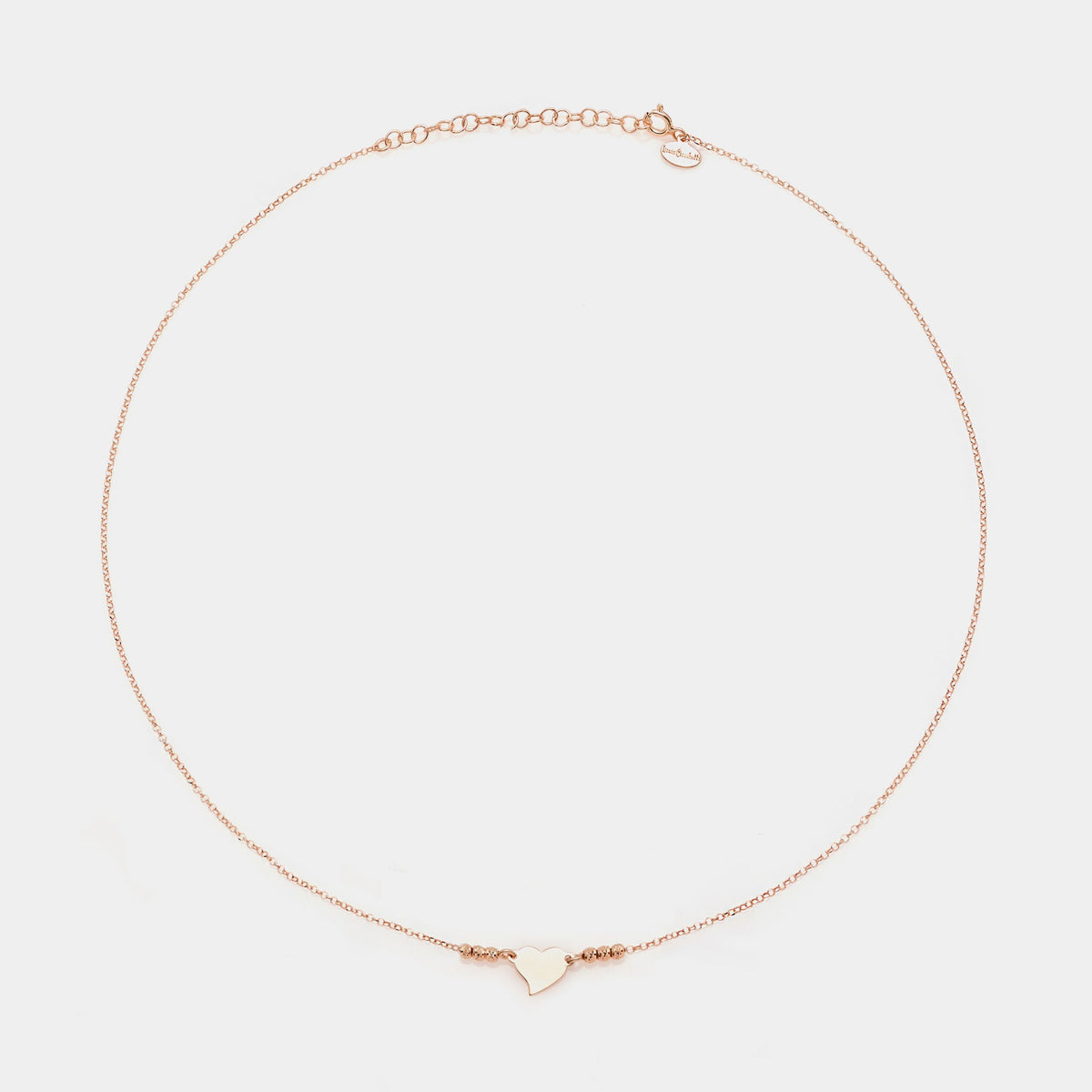 Rose gold silver necklace with twisted heart centerpiece and 3 faceted spheres on the sides