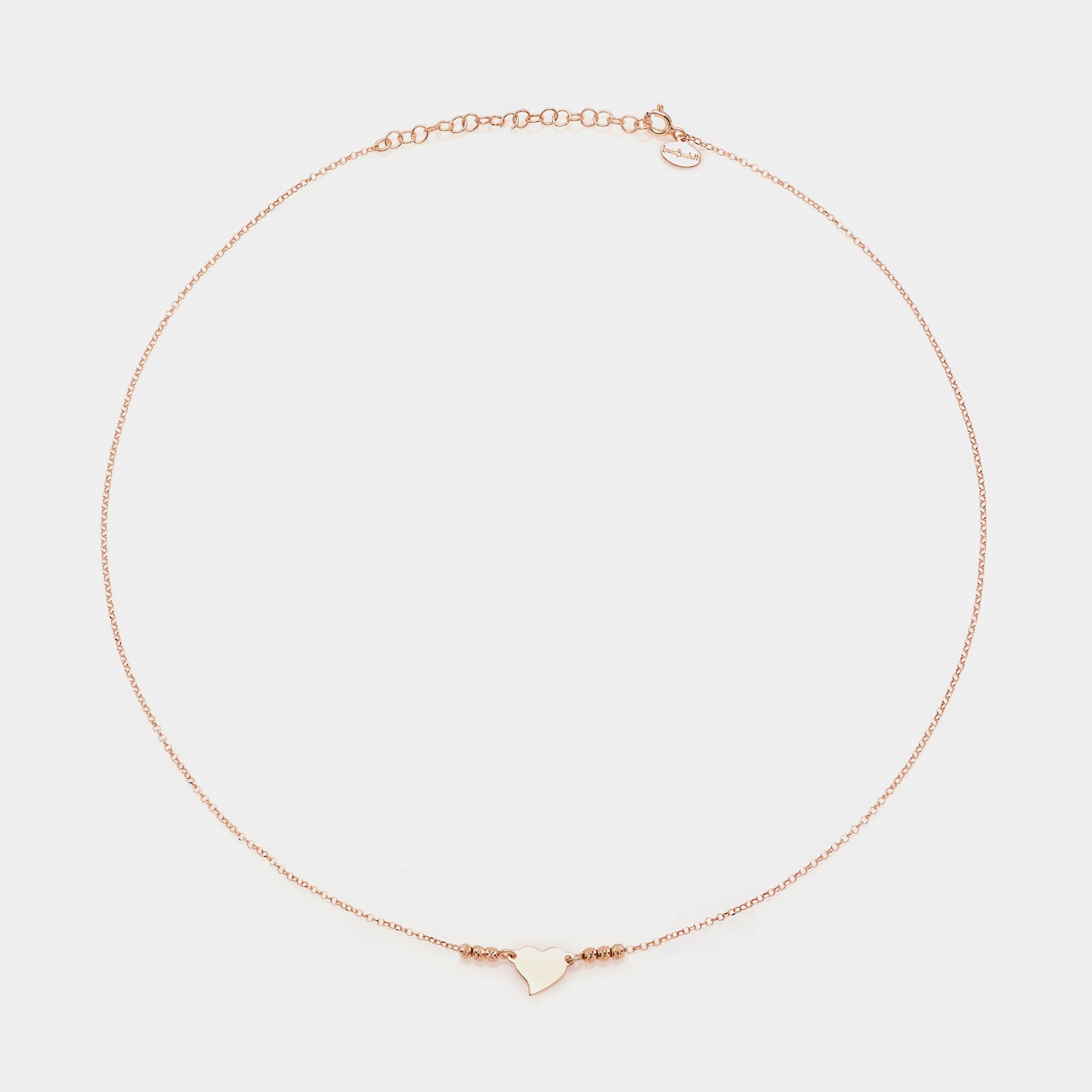 Rose gold silver necklace with twisted heart centerpiece and 3 faceted spheres on the sides