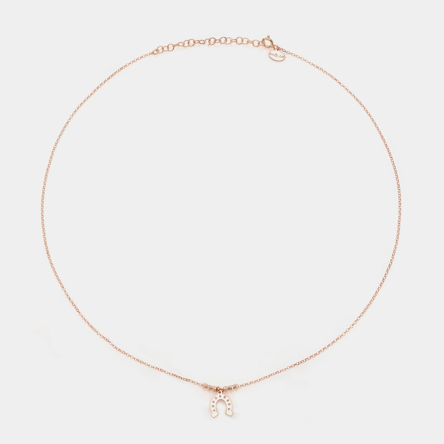 Rose gold silver necklace with a central hanging horseshoe and faceted spheres on the sides