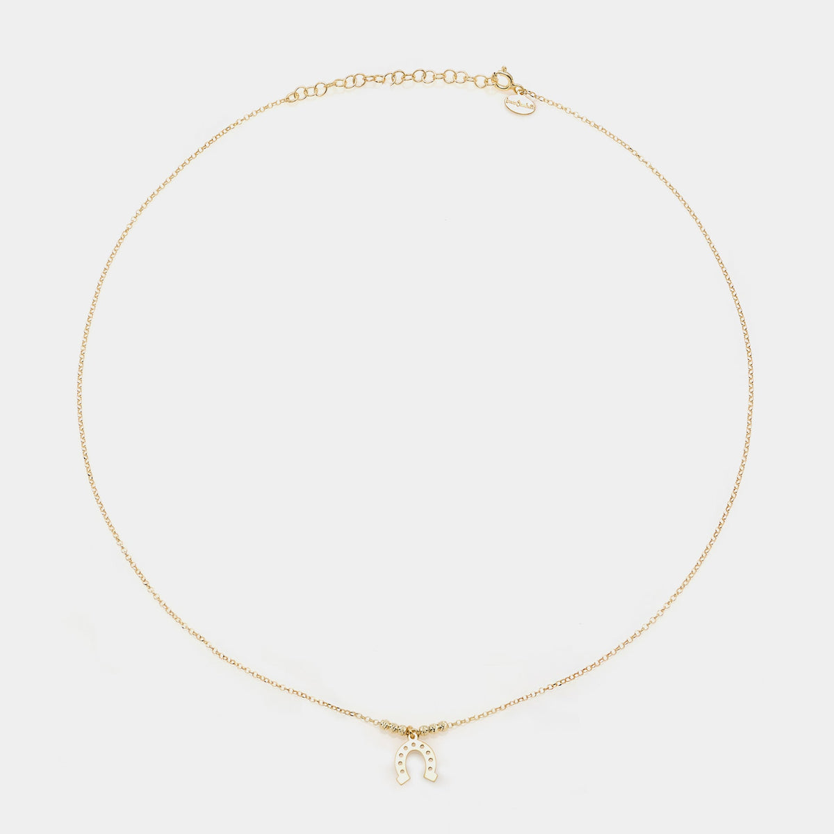Gold-plated silver necklace with a hanging horseshoe centerpiece and faceted spheres on the sides