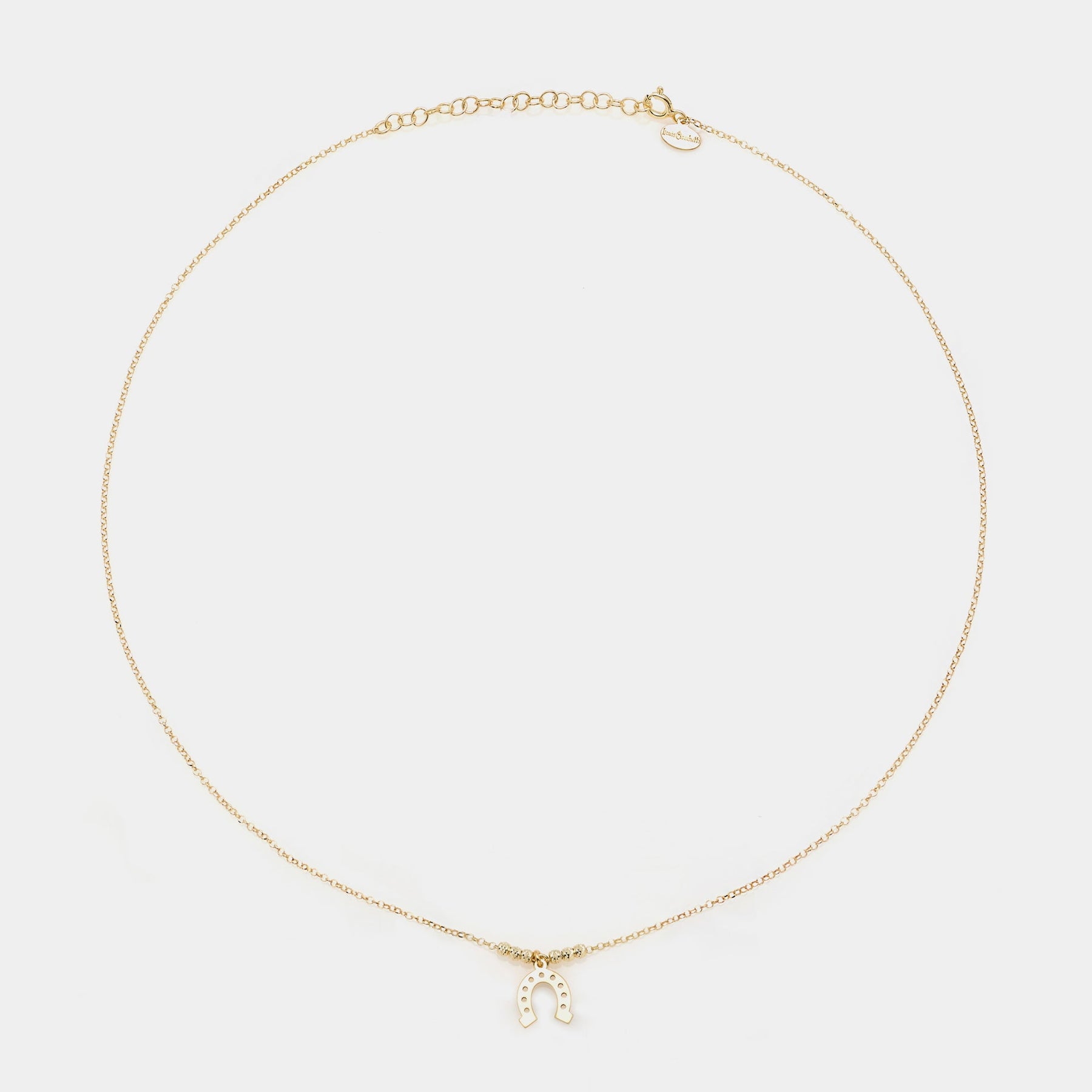 Gold-plated silver necklace with a hanging horseshoe centerpiece and faceted spheres on the sides