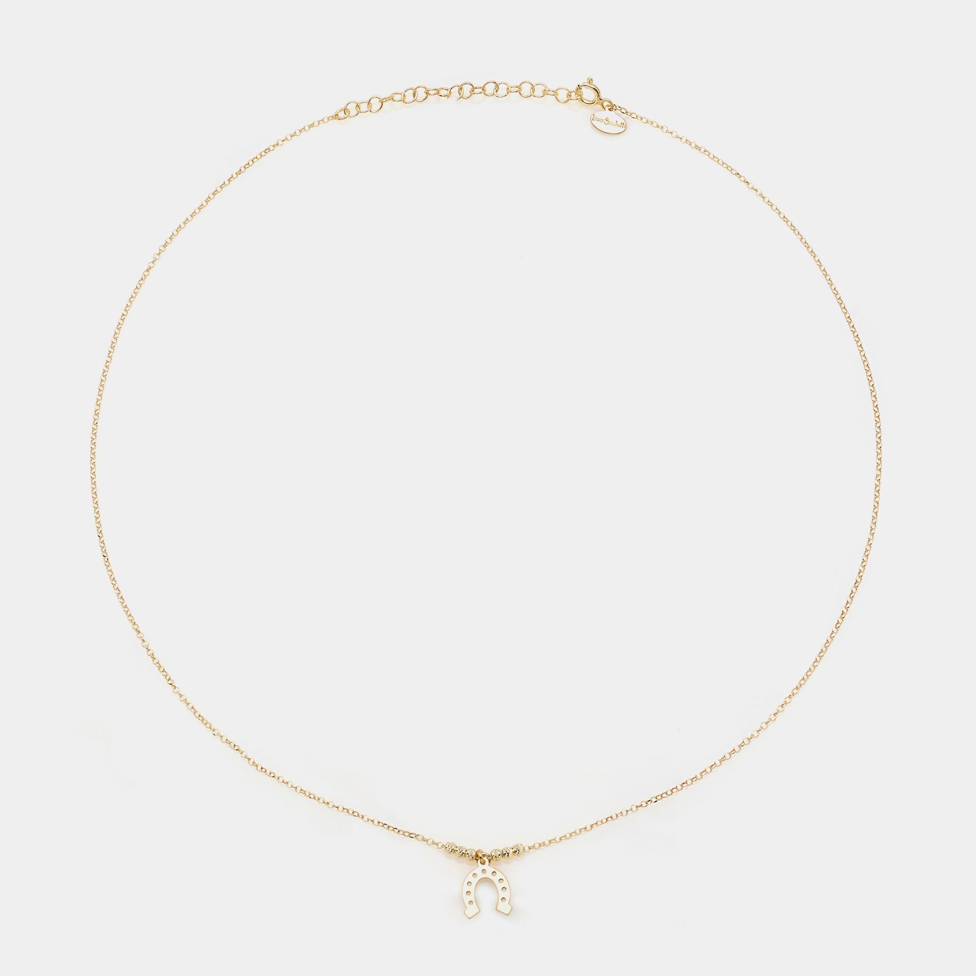 Gold-plated silver necklace with a hanging horseshoe centerpiece and faceted spheres on the sides