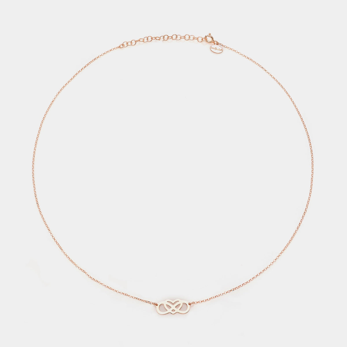 Collar de plata rosa con centro de infinito entrelazado y perforado y corazón