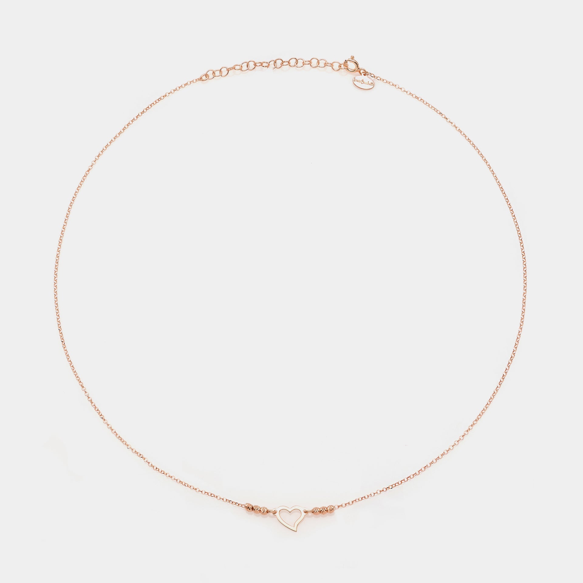 Rose gold silver necklace with twisted heart centerpiece and 3 faceted spheres on the sides