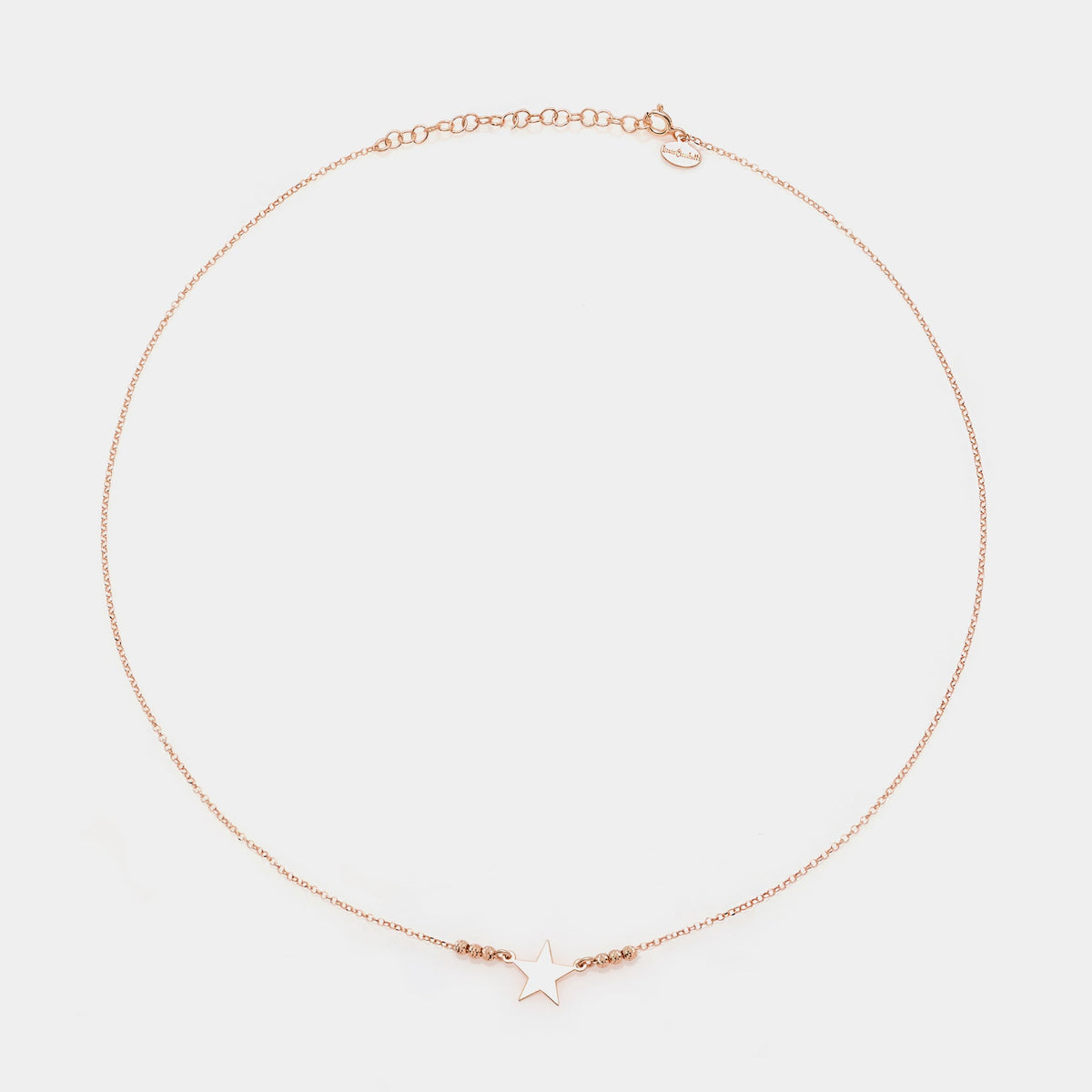Rose gold silver necklace with star centerpiece and 3 faceted spheres on the sides