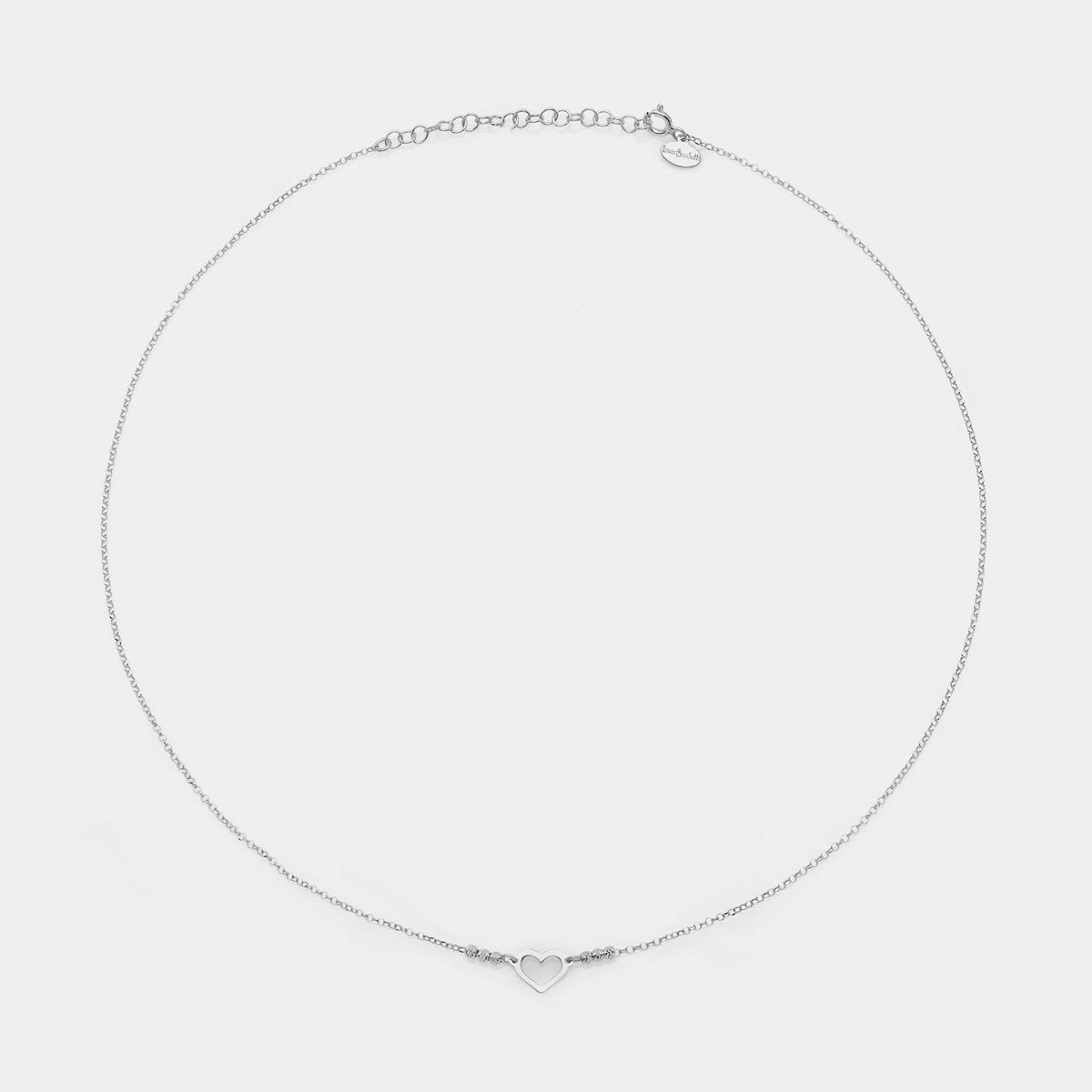 Rhodium-plated silver necklace with simple pierced heart centerpiece and 3 faceted spheres on the sides