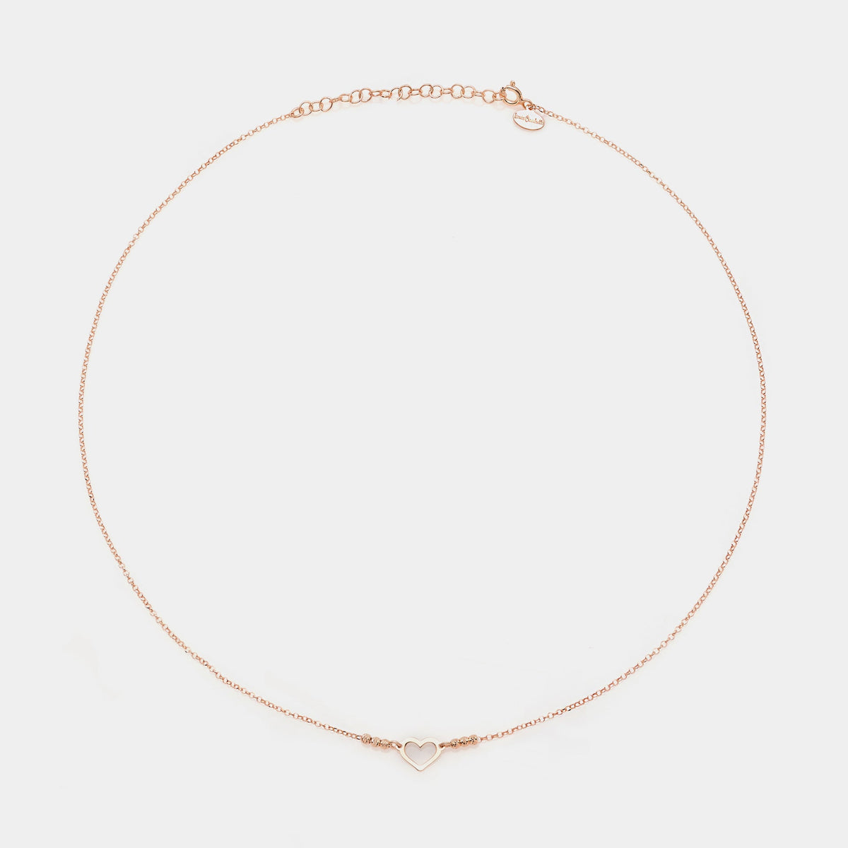 Rose gold silver necklace with simple pierced heart centerpiece and 3 faceted spheres on the sides