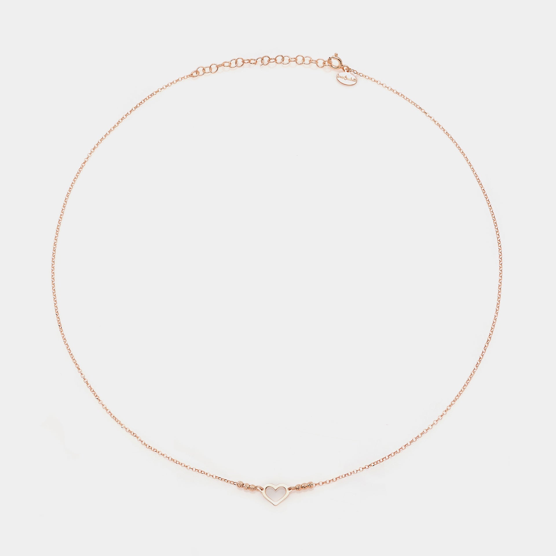 Rose gold silver necklace with simple pierced heart centerpiece and 3 faceted spheres on the sides
