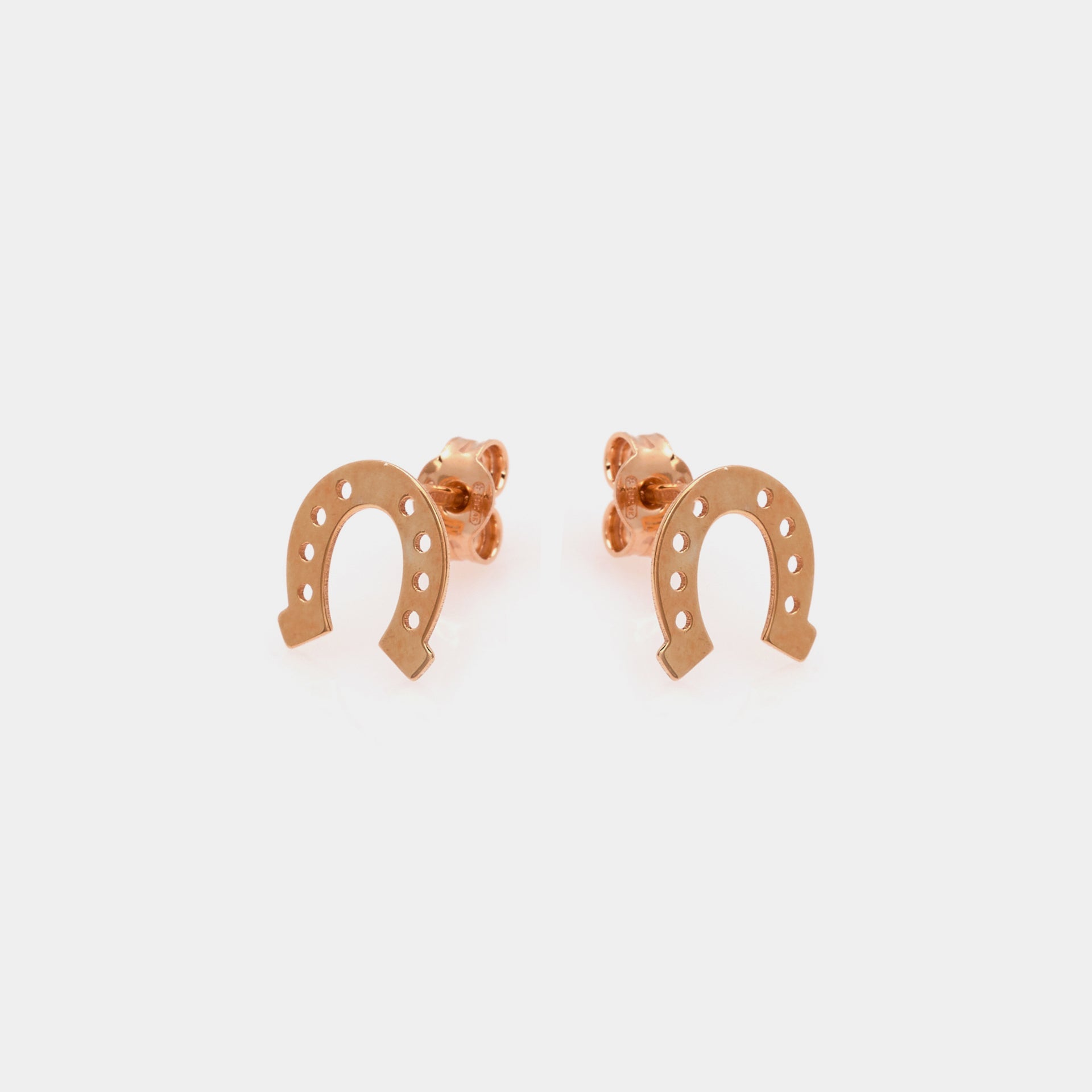 Rose gold plated silver stud earrings in the shape of a horseshoe
