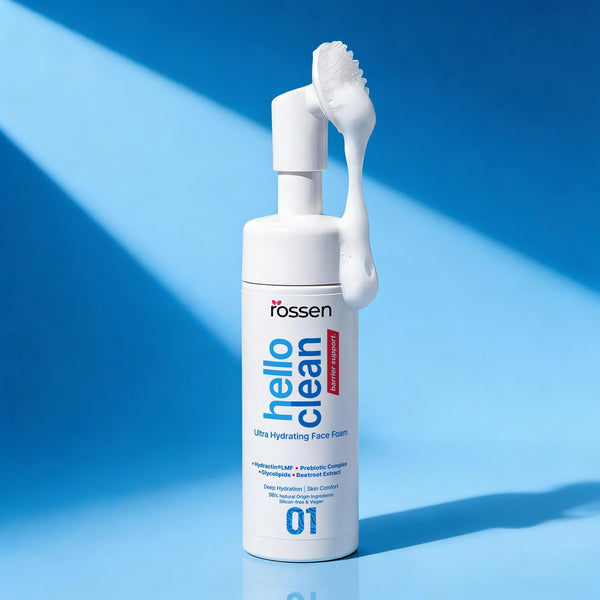 White pump bottle of a facial cleanser with foam resting on the pump against a blue background; product labeled 'hello clean' Ultra Hydrating Face Foam.