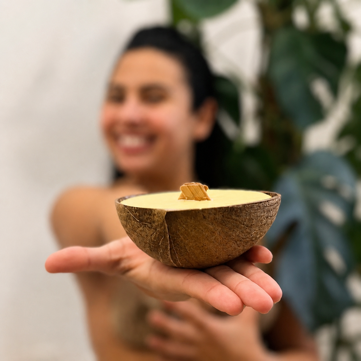 Person holding a CocoBee coconut shell candle with wooden wick