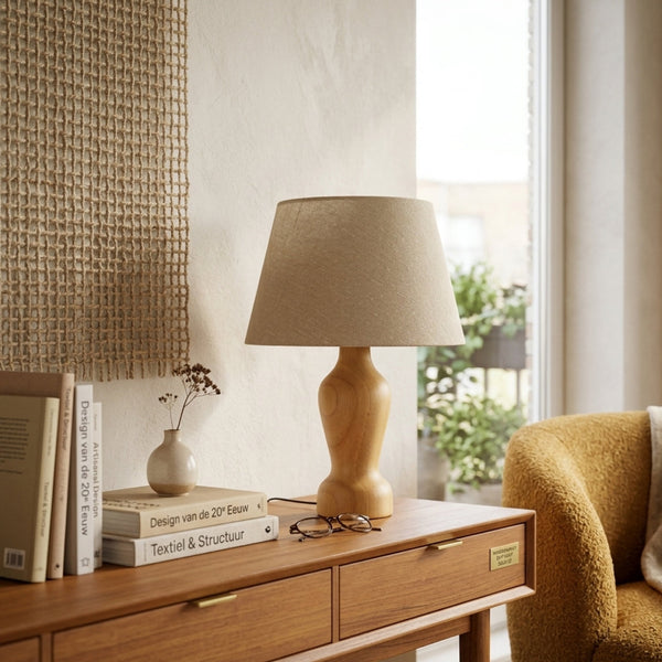 Tafellamp Mona op een houten dressoir in een modern Scandinavisch interieur met boeken en een klein vaasje.
