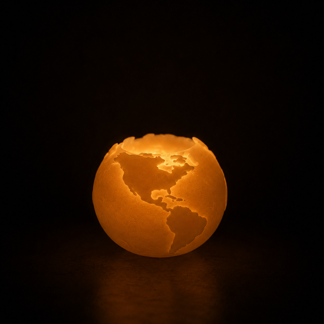 Lit globe-shaped beeswax candle by CocoBee