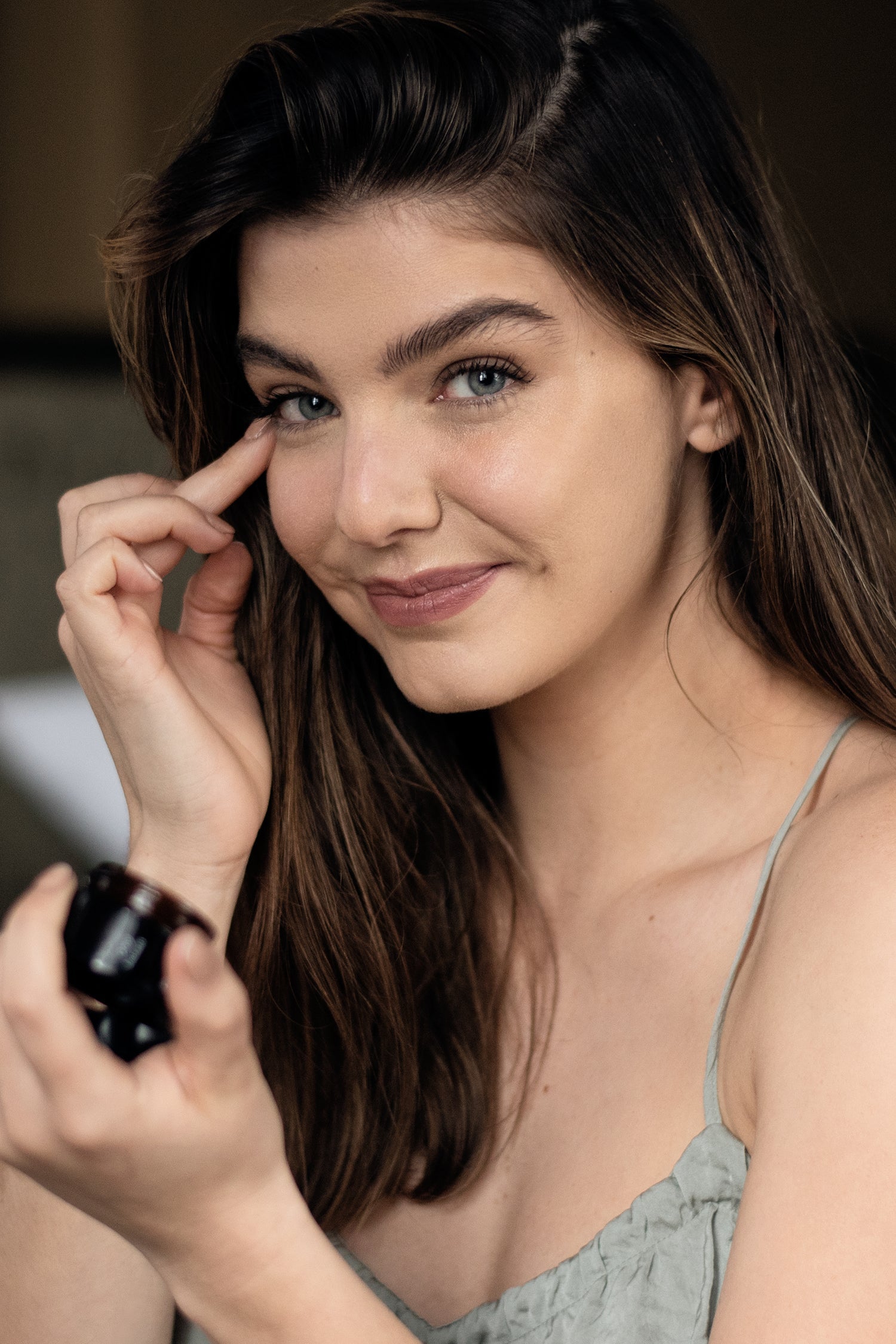 Žena nanáša očný balzam Sedem byliniek na jemnú pleť okolo očí