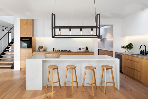 Onder een trendy zwart hanglamp biedt deze sfeerfoto een uitnodigende ambiance. Perfect voor elke moderne setting.