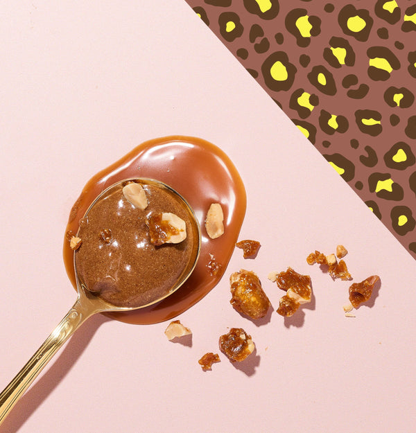 Cuillère dorée de Pâte à tartiner Chouchou avec éclats de chouchous caramélisés sur fond rose et léopard